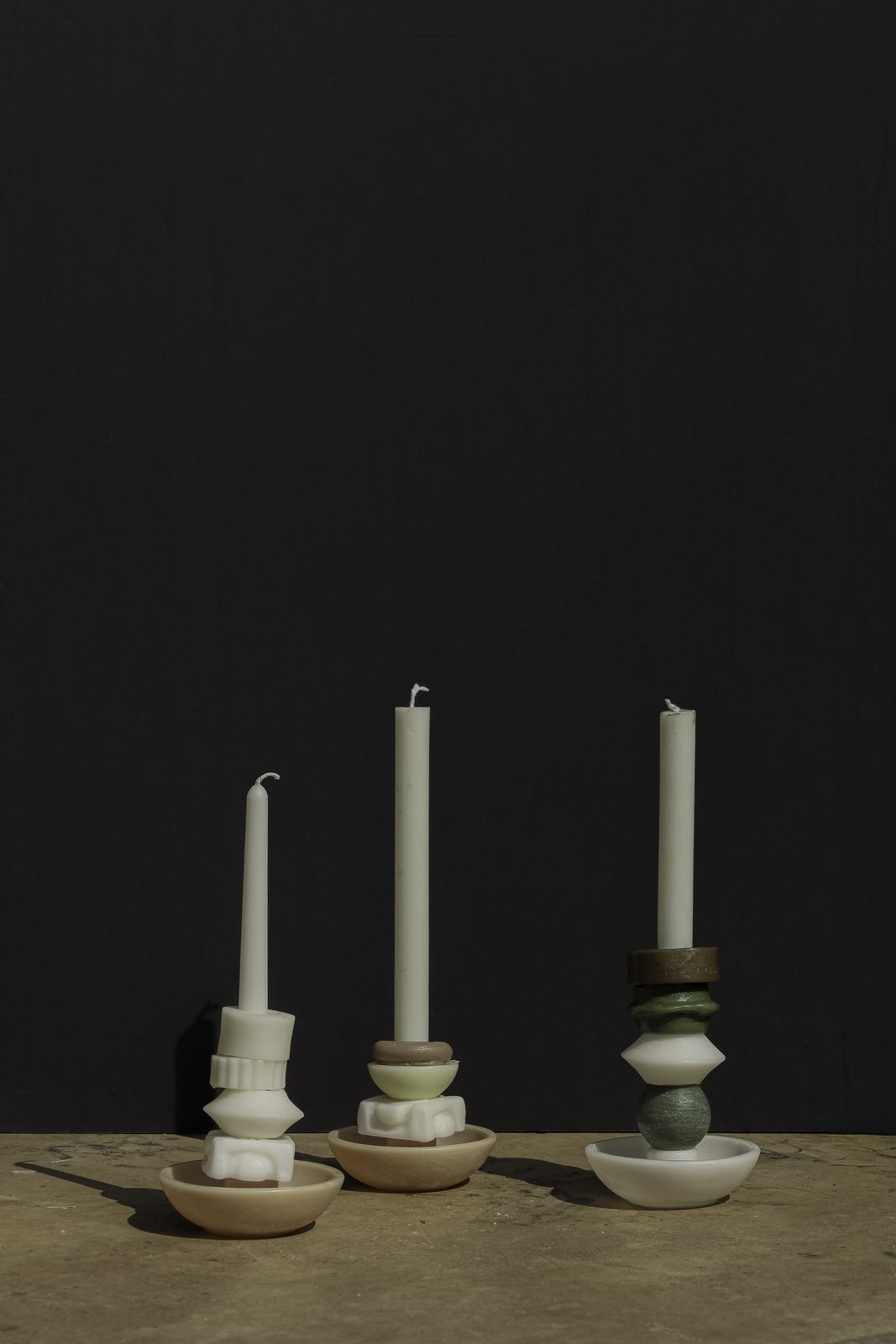 Three ivory stacked candles on their wax holders