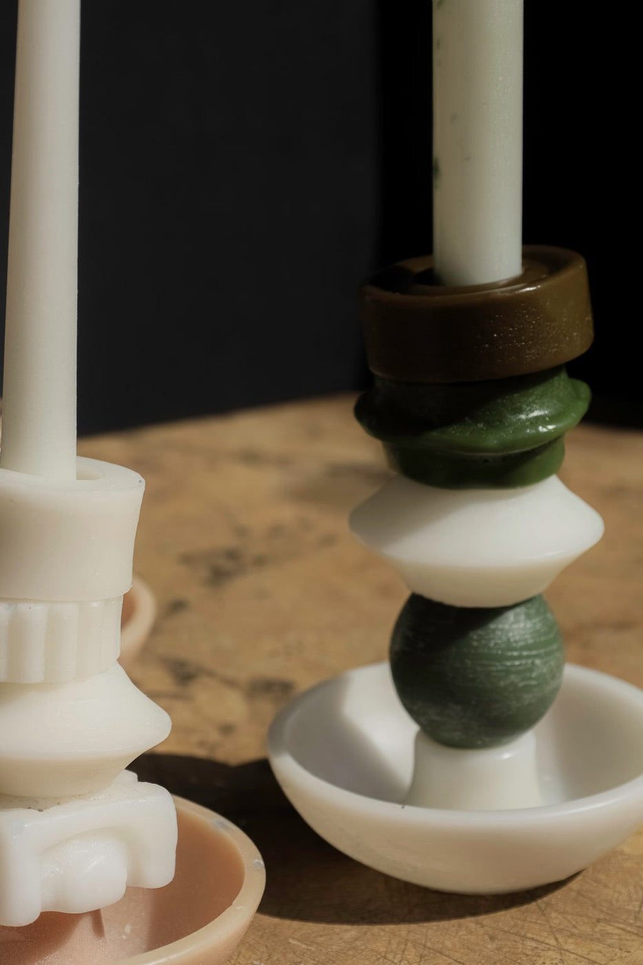 Close-up of an olive ring and moss dome supporting an ivory taper